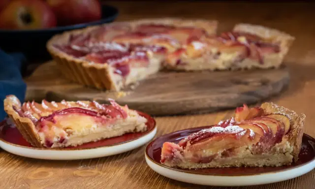 Saftige Apfeltarte mit roten Apfelscheiben, bestäubt mit Puderzucker. Ein köstliches Apfeltarte Rezept für Genießer.