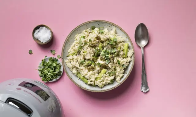 Reis mit Pesto und Spargel, garniert mit Kresse. Daneben Salz, Sprossen und ein Löffel.