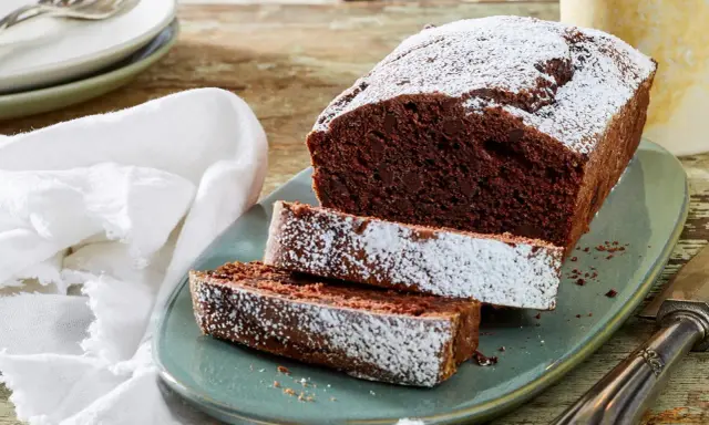 Saftiger Schokoladen-Pfundkuchen, bestäubt mit Puderzucker. Dieses Rezept für Pfundkuchen ist ein Genuss!
