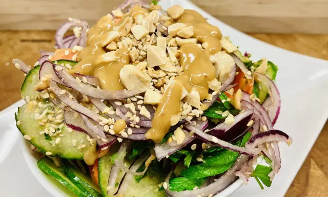 Frischer Salat mit Gurke, roten Zwiebeln, Erdnüssen und einer cremigen Erdnuss-Dressing. Ein köstlicher ingwer salat.