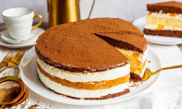 Schokoladenkuchen mit Sahne und Fruchtfüllung, ein köstlicher Kuchen, der 3 Tage durchziehen muss, bestäubt mit Kakao.