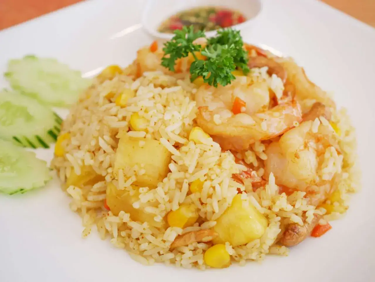 Ein k&ouml;stlicher Reis mit Garnelen, Mais und Ananasst&uuml;cken, garniert mit Petersilie. Ein Hauch von Curry verleiht diesem Gericht eine besondere Note.