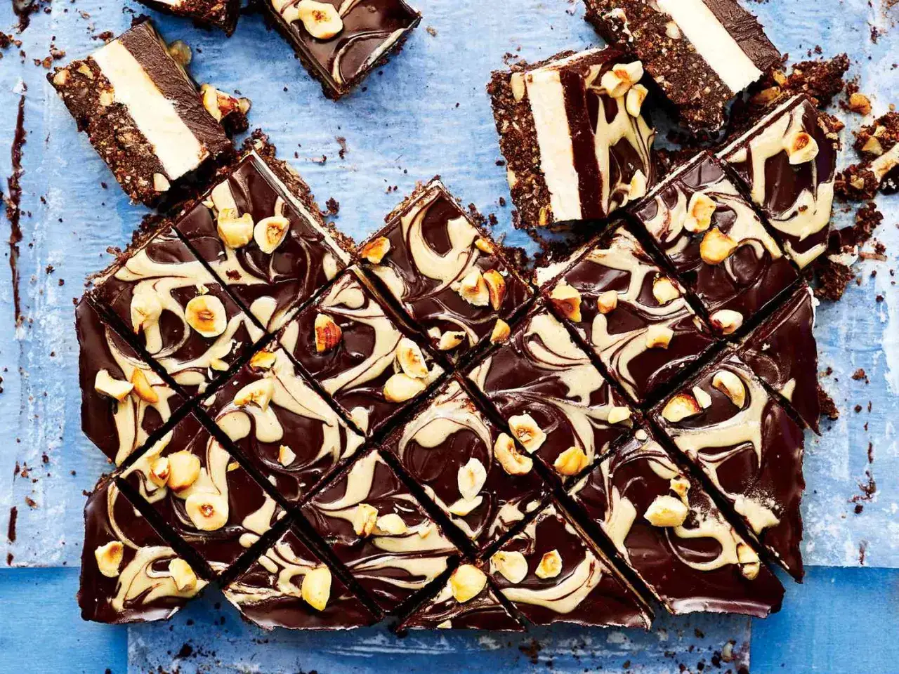 Ausgefallene Desserts zum Vorbereiten: Schokoladen-Nuss-Riegel mit cremiger F&uuml;llung und Swirl-Muster, garniert mit Haseln&uuml;ssen.