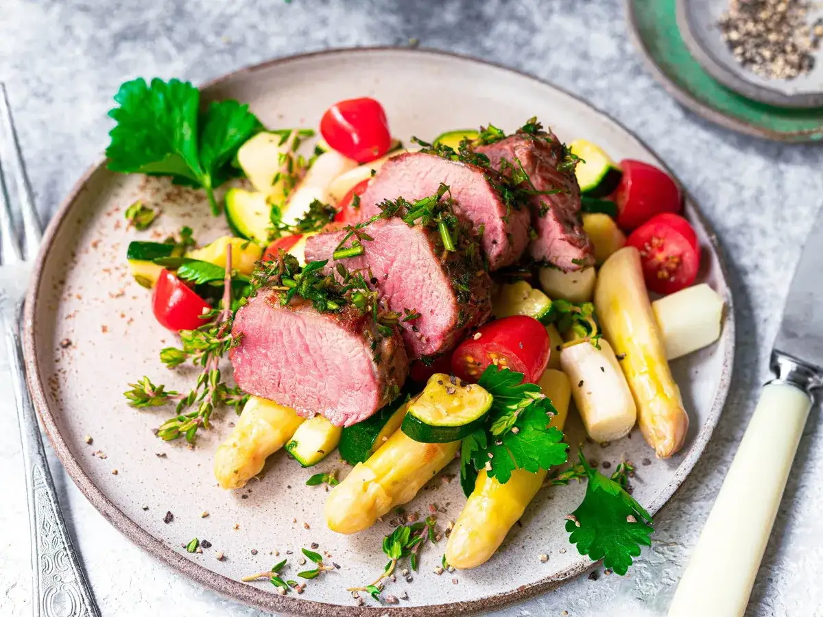 Saftiges Lammkarree mit Spargel, Zucchini und Kirschtomaten – tolle Oster-Essen-Ideen für ein festliches Menü.