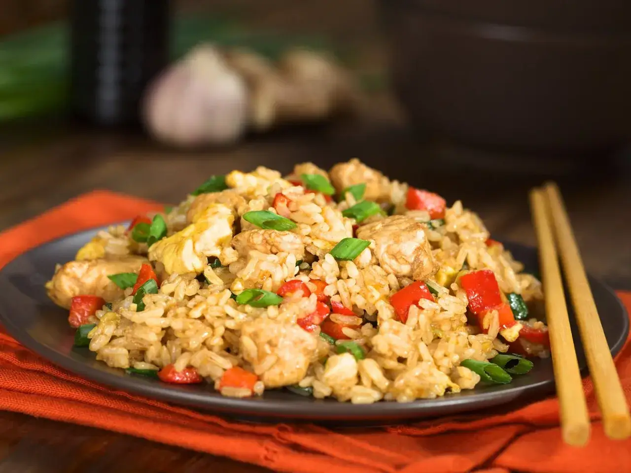 Ein Teller Nasi Goreng, ein beliebtes indonesisches Gericht, mit gebratenem Reis, H&uuml;hnchen, Garnelen, Paprika und Fr&uuml;hlingszwiebeln.