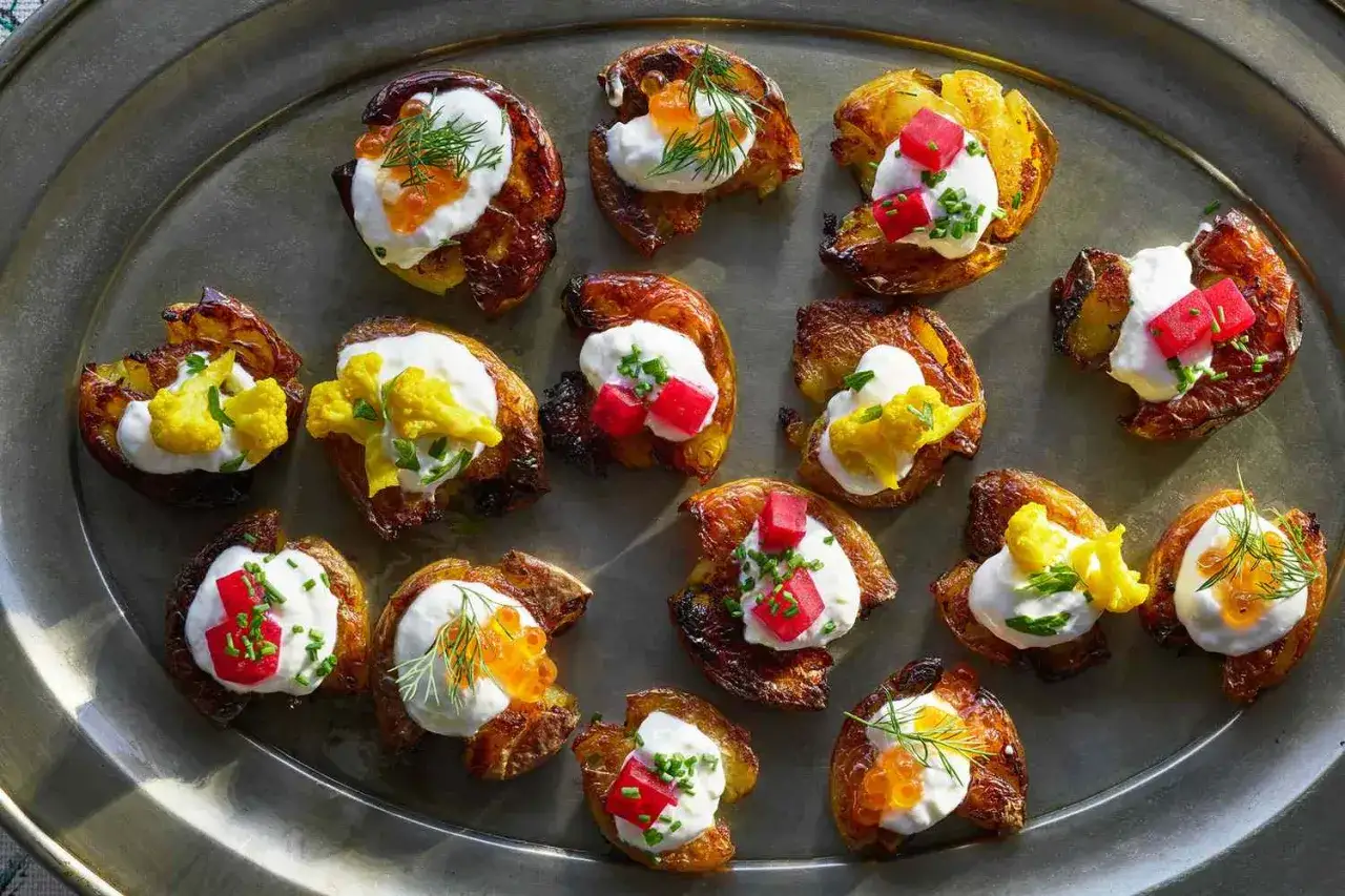 Salziges Fingerfood: Knusprige Kartoffeln mit cremigem Topping, Kaviar, roten W&uuml;rfeln oder gelbem Blumenkohl.