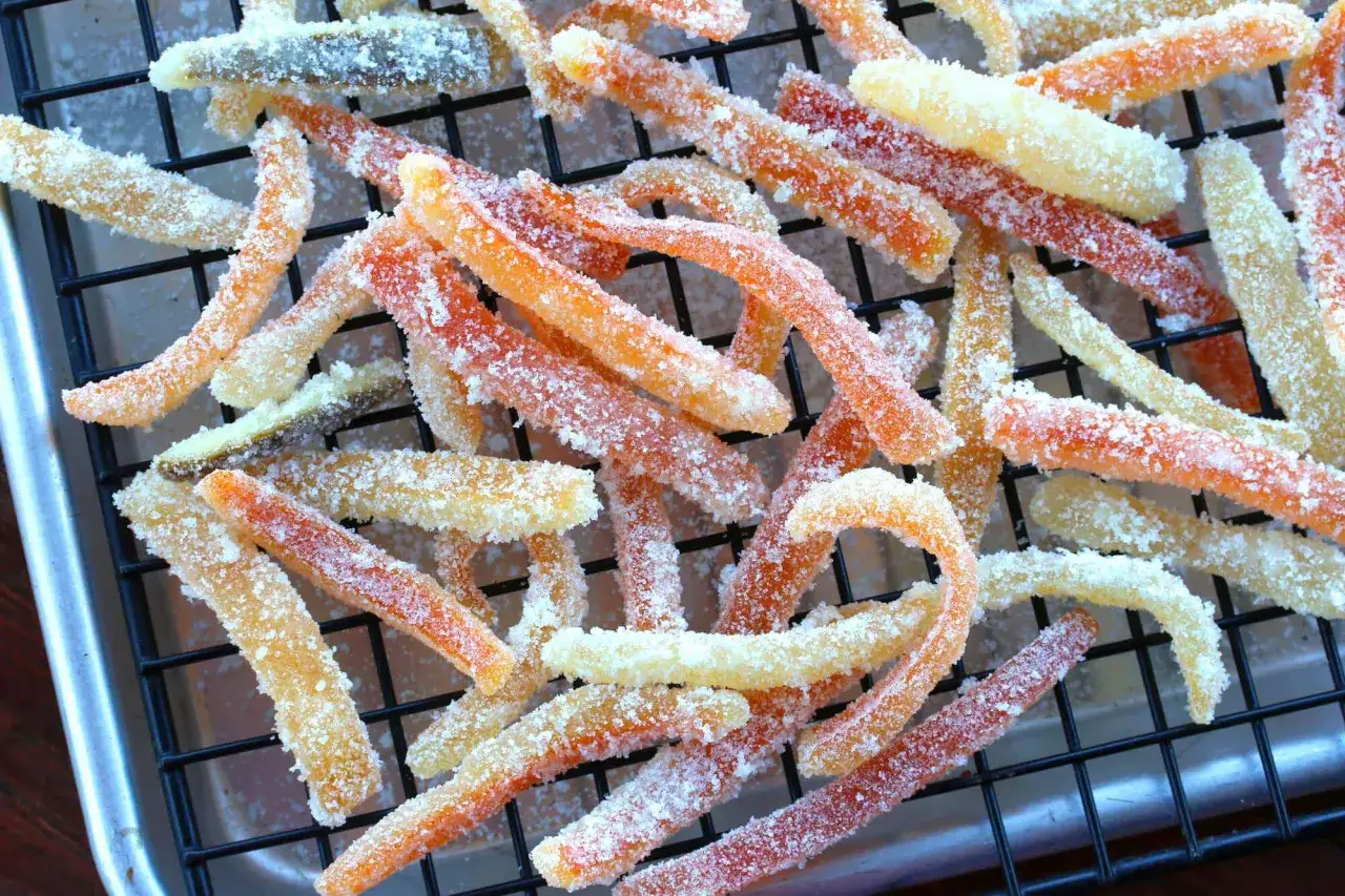 Kandierte Orangenzesten, selbstgemacht und in Zucker gewälzt, trocknen auf einem Gitter. Ein süßer Genuss!