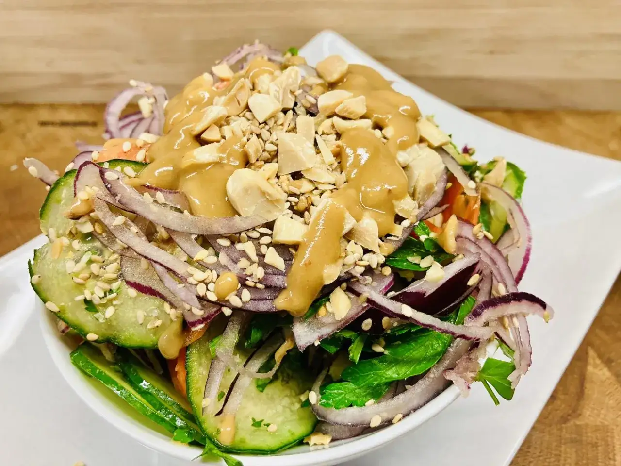Frischer Salat mit Gurke, roten Zwiebeln, Erdnüssen und einem cremigen Dressing. Ein köstlicher Ingwersalat, der Lust auf mehr macht.