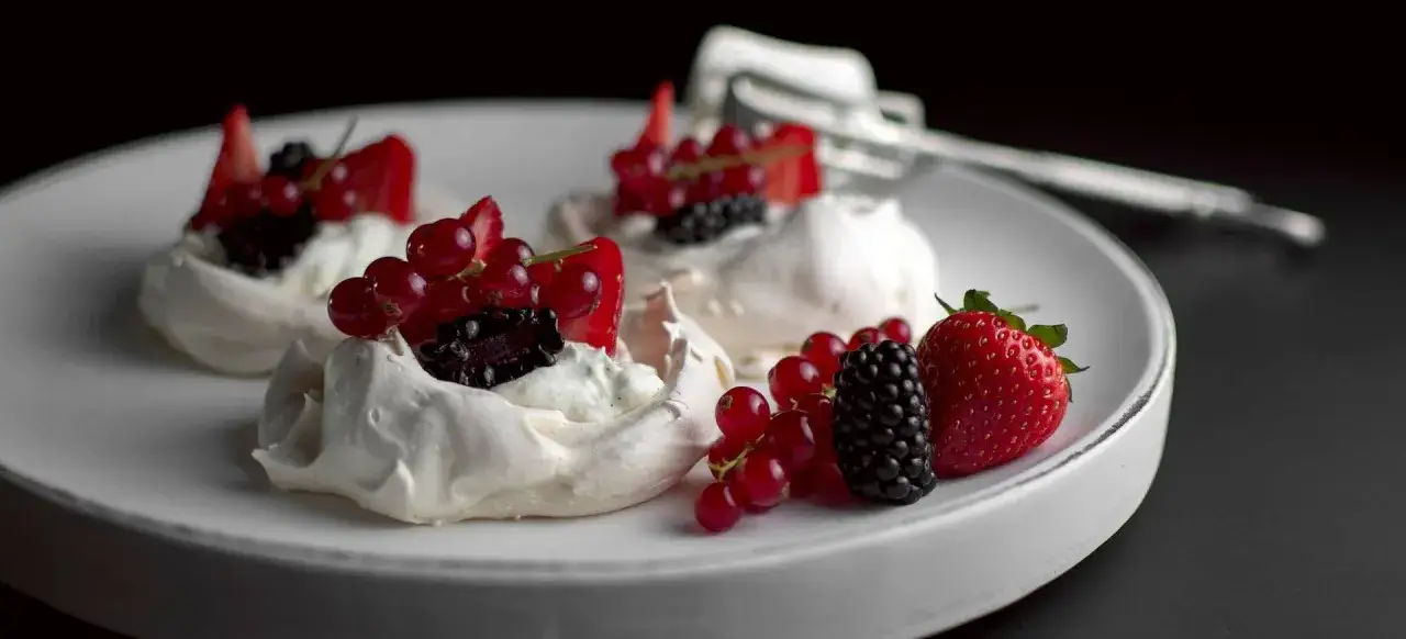 Luftige Meringue-T&ouml;rtchen mit frischen Beeren und Sahne. Ein s&uuml;&szlig;er Traum, der zeigt, was ist Meringue: Baisergeb&auml;ck.