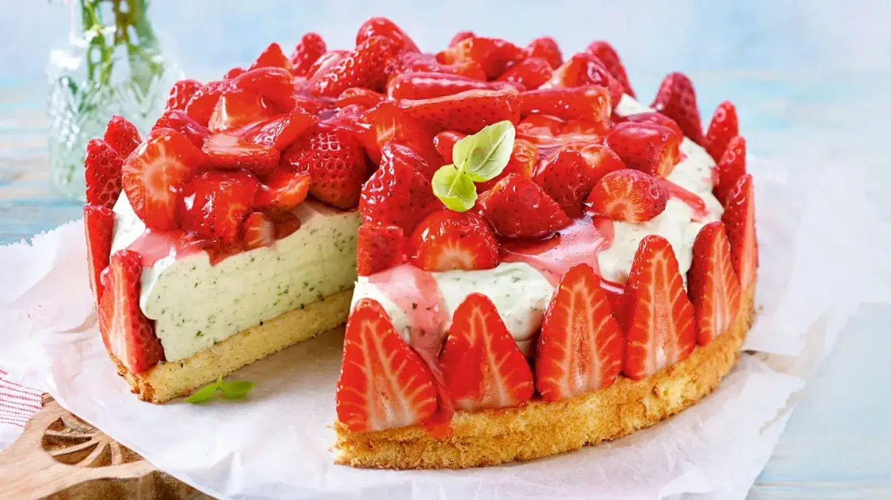 Erdbeer-Basilikum-Torte: Ein saftiger Boden, cremige F&uuml;llung mit Basilikum und frische Erdbeeren, verziert mit Erdbeersauce und Basilikumblatt.