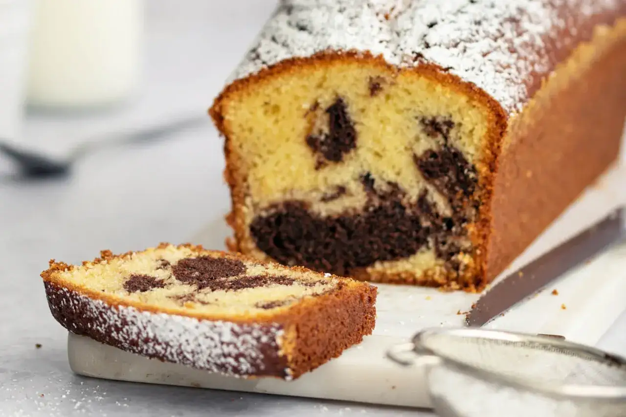 Ein saftiger Marmorkuchen, perfekt für jedes pfundkuchen rezept. Mit Puderzucker bestäubt und einer Scheibe zum Genießen.