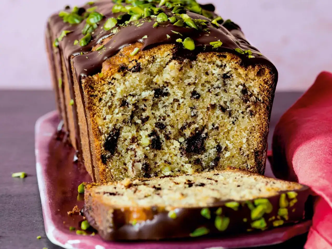 Saftiger Vanillekuchen mit Puddingpulver in Kastenform, &uuml;berzogen mit Schokolade und gehackten Pistazien.